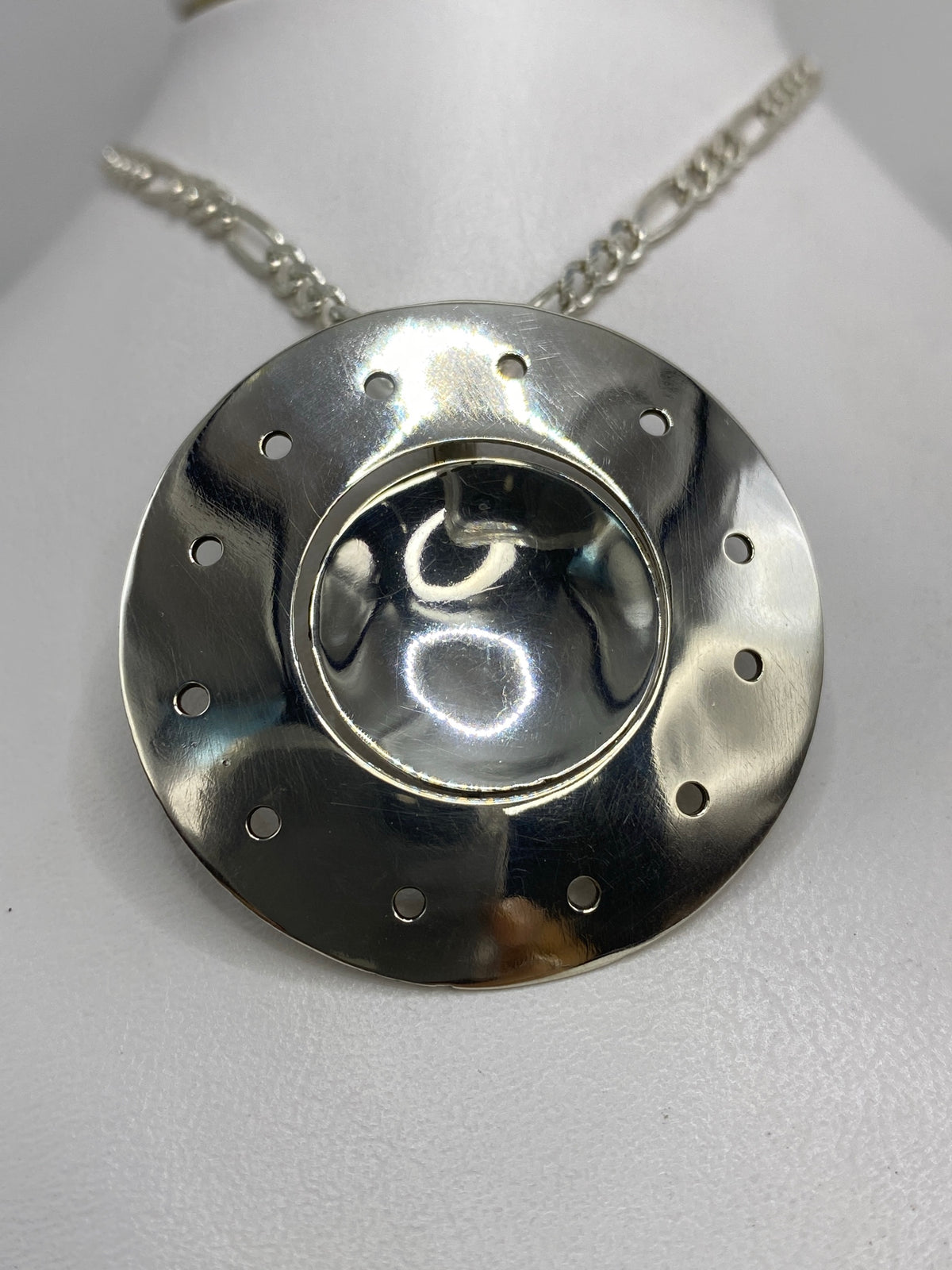 Detalle del dije mostrando el diseño circular minimalista en plata 925