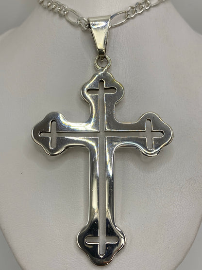 Dije cruz de plata 925 de Taxco con brazos curvados sobre fondo blanco