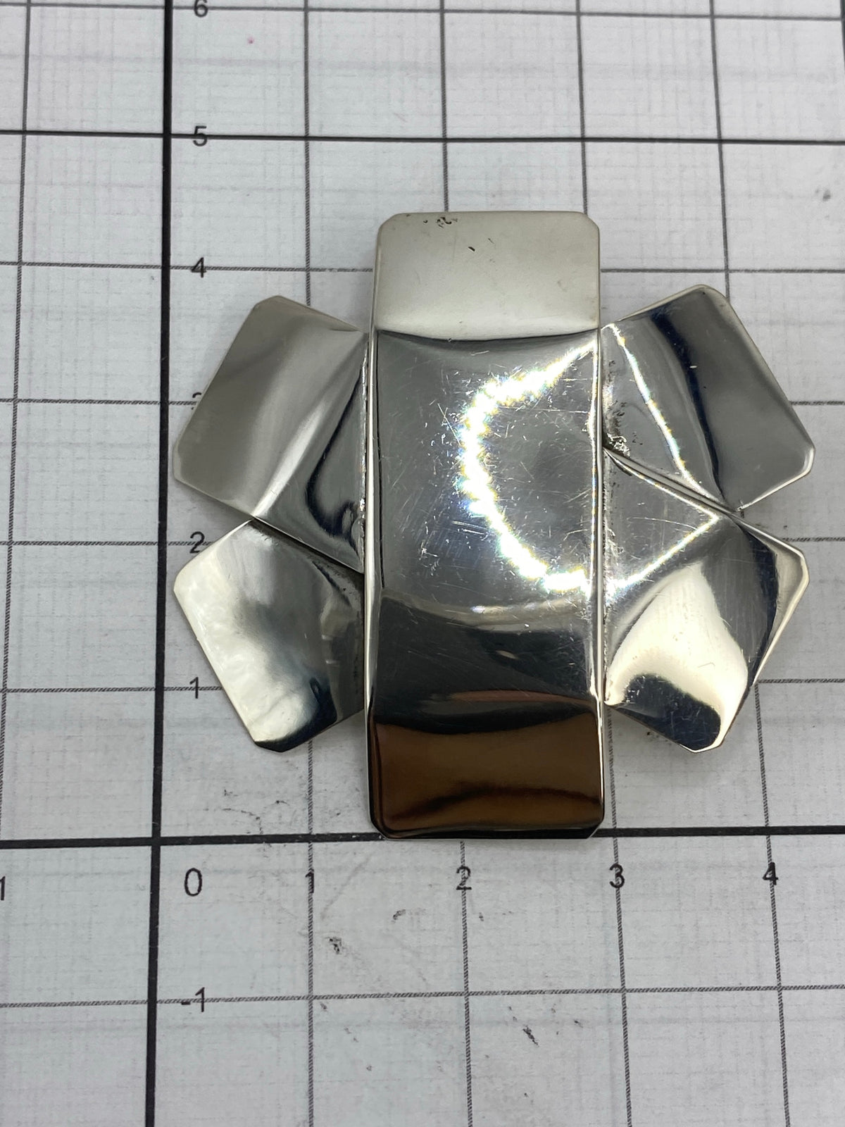 Dije sobre regla mostrando tamaño exacto de 4.2 × 4.2 cm