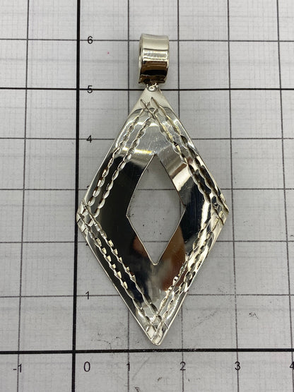 Dije sobre papel milimetrado mostrando medidas: 6 cm largo × 3 cm ancho