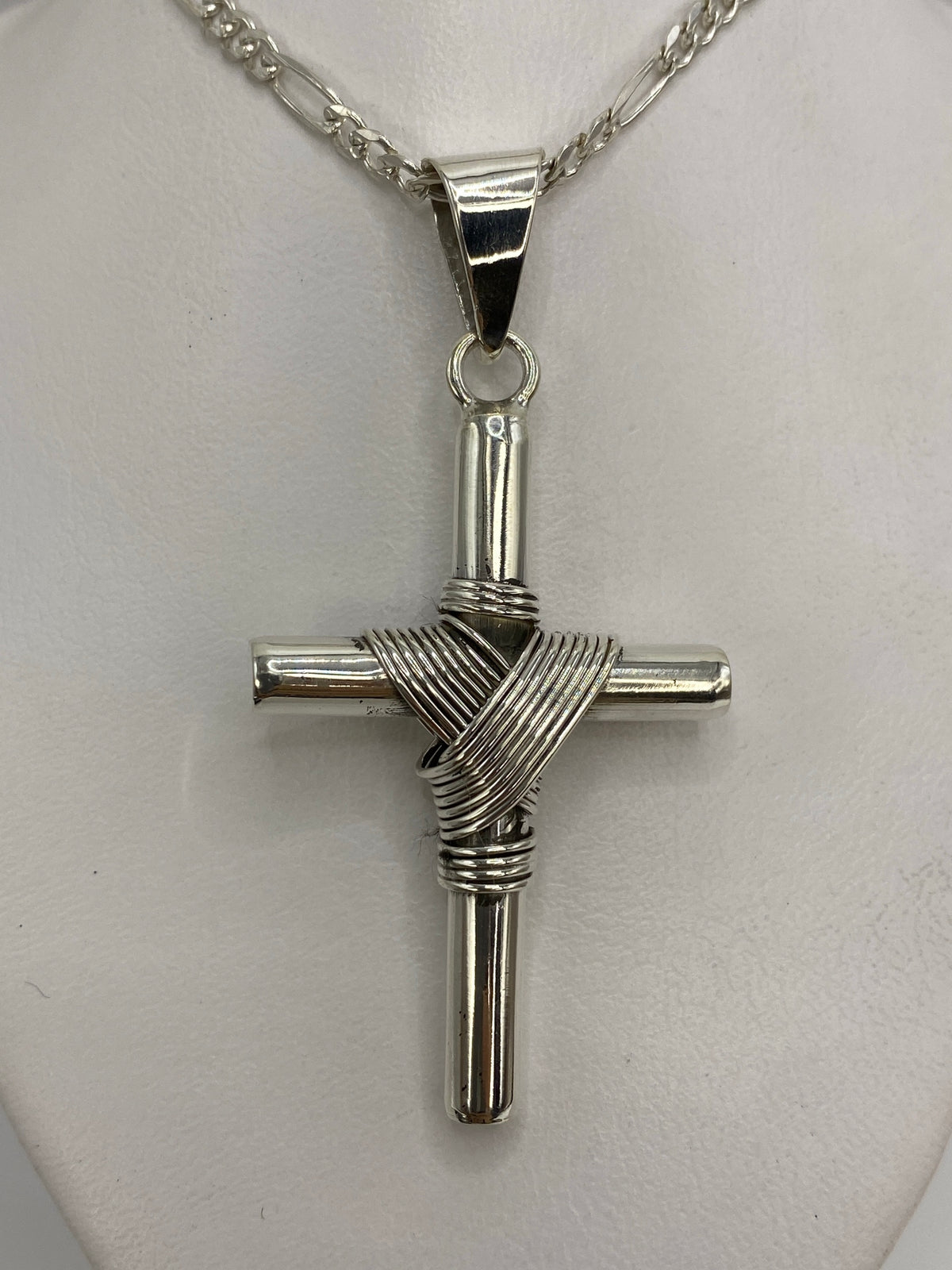 Detalle frontal de la cruz de plata mostrando el entrelazado de hilos artesanal