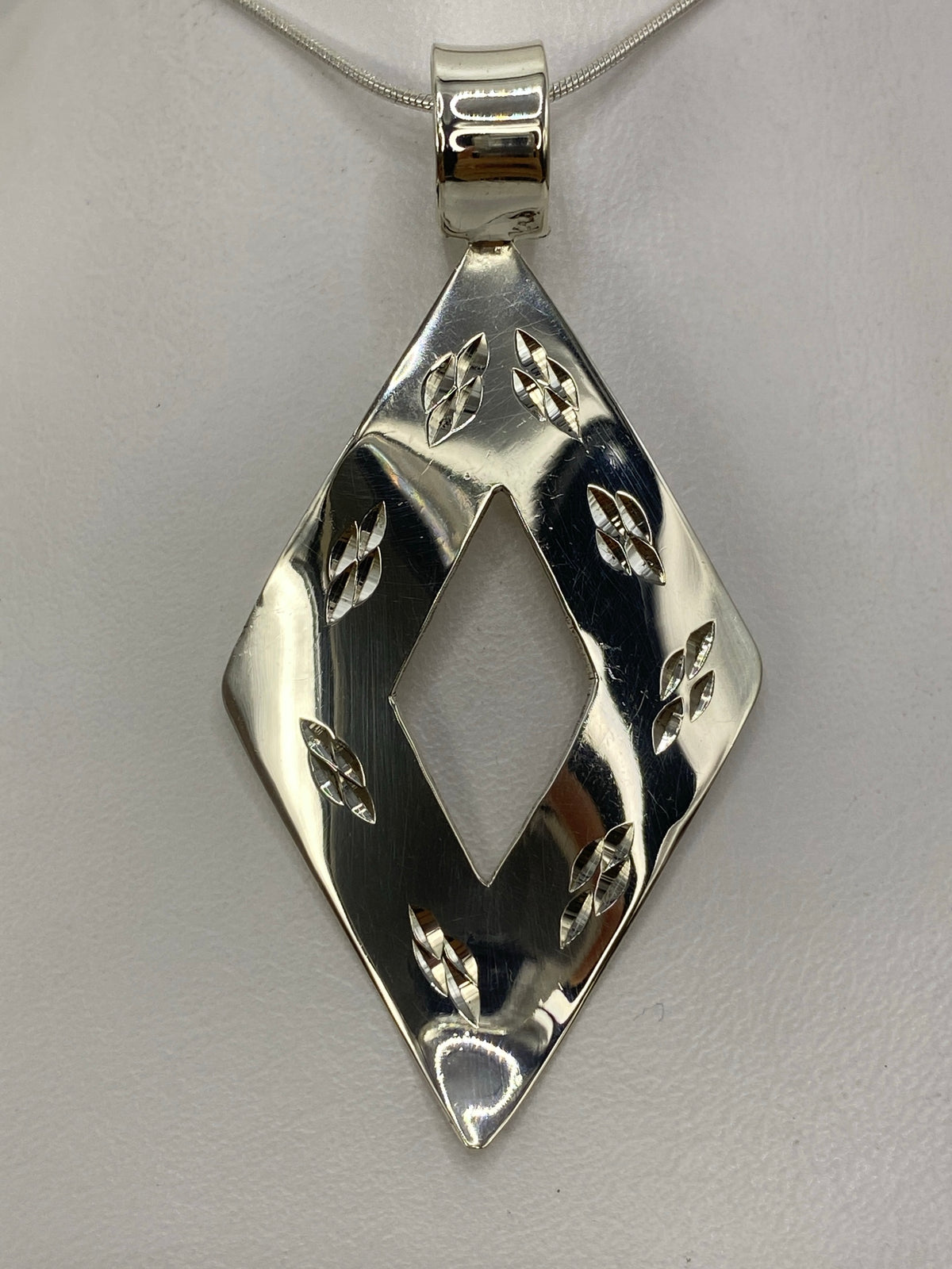 Detalle del acabado pulido del dije reflejando luz