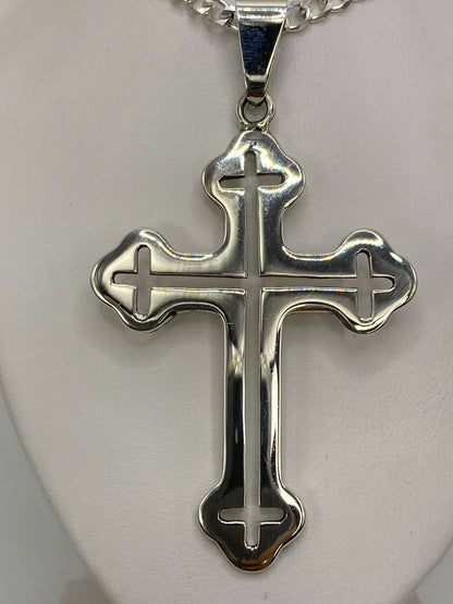 Cruz de plata 925 sobre regla en centímetros, midiendo 8 cm de largo