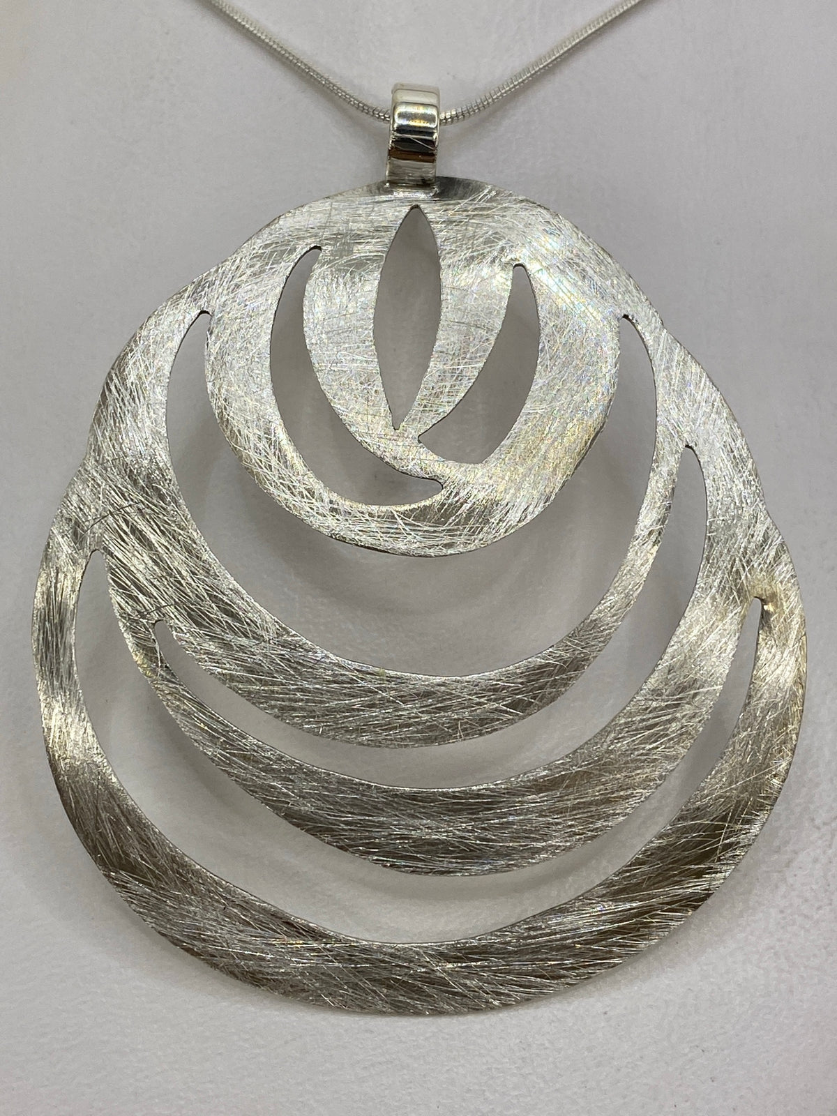 Dije de plata 925 sobre fondo blanco, vista frontal, 6 × 5 centímetros