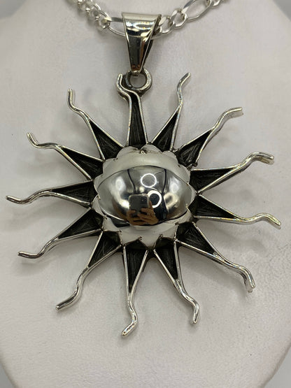 Dije sol prehispánico de plata 925 con esfera pulida y doce rayos curvados, vista frontal