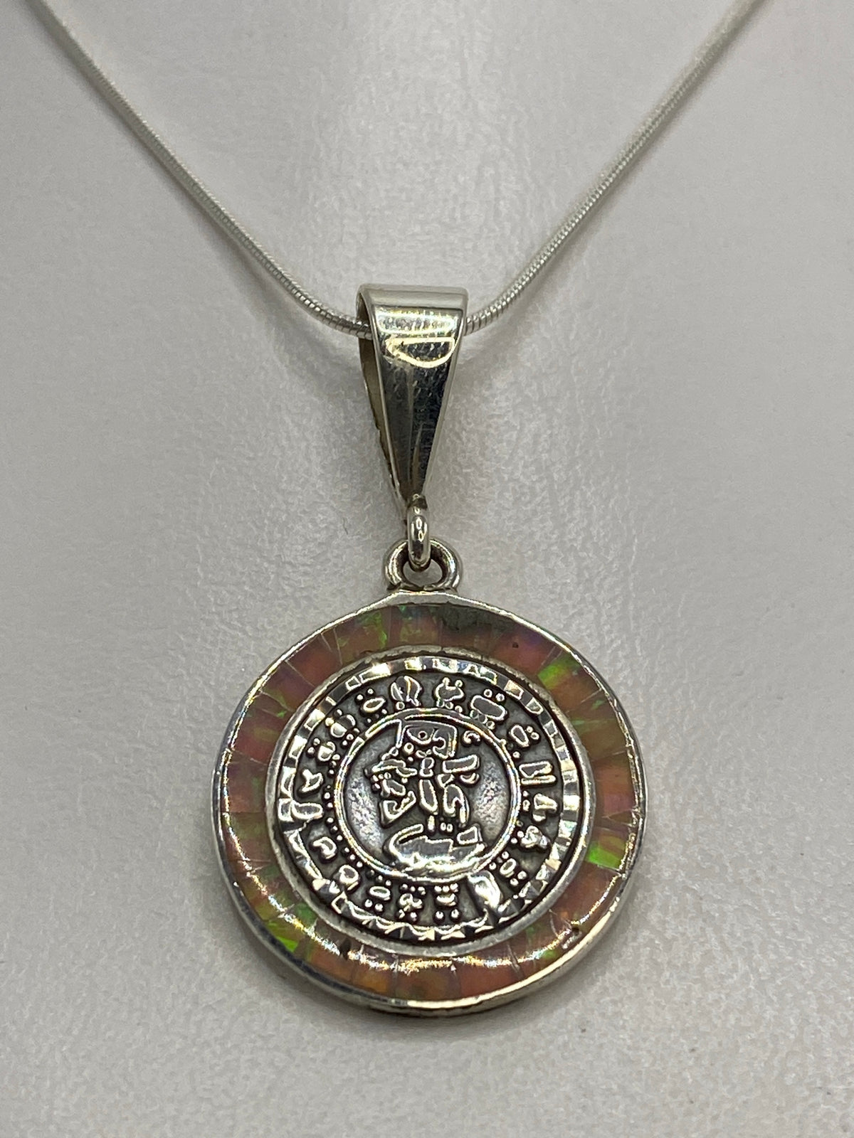 Vista frontal del diseño prehispánico tallado en plata con glifos aztecas