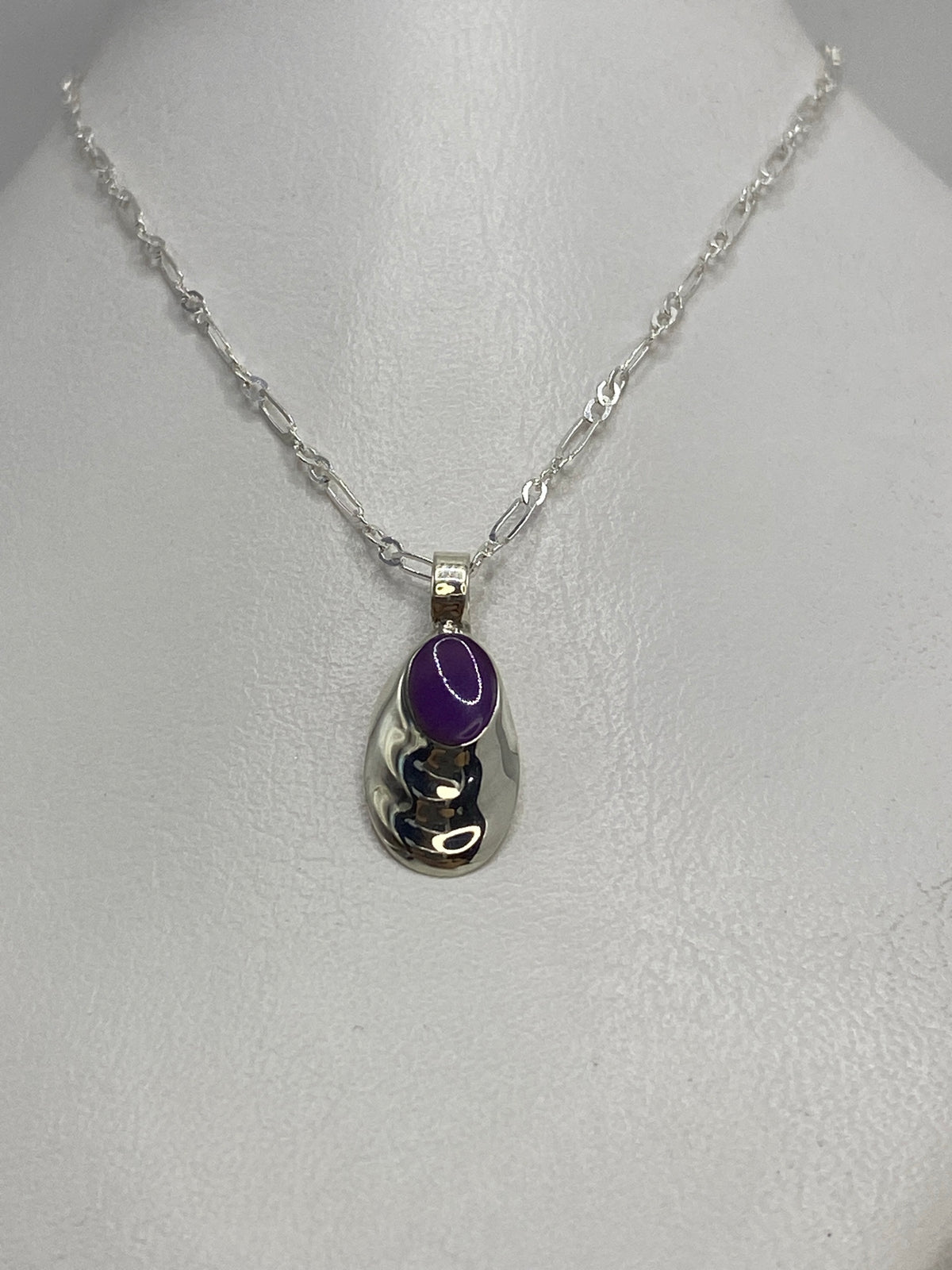 Detalle del engaste de piedra morada en plata, vista de frente