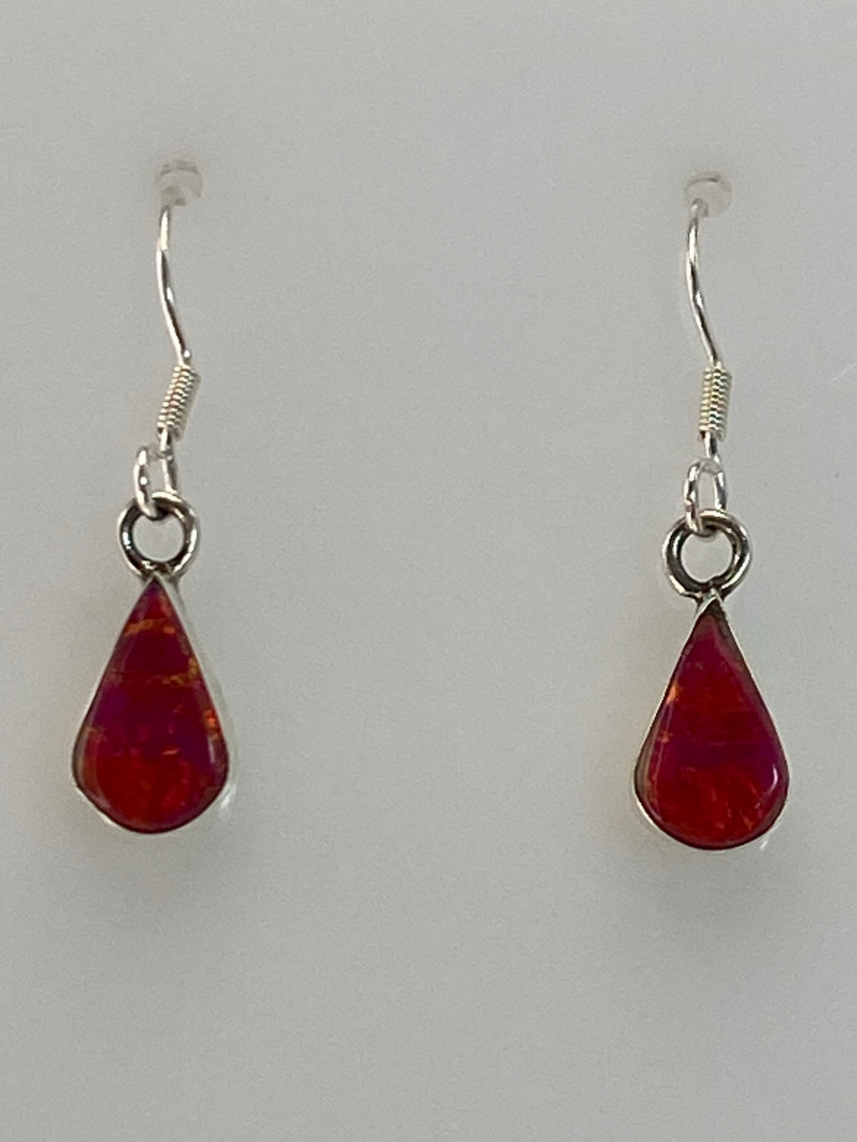 Par de aretes de plata 950 con ópalo de fuego rosa, engastados a mano, sobre fondo blanco