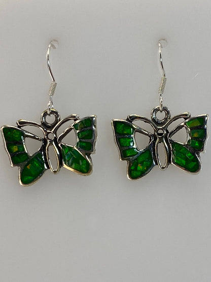 Par de aretes de plata 950 con ópalo de fuego verde, colgando del gancho, viendo la iridiscencia natural de la piedra