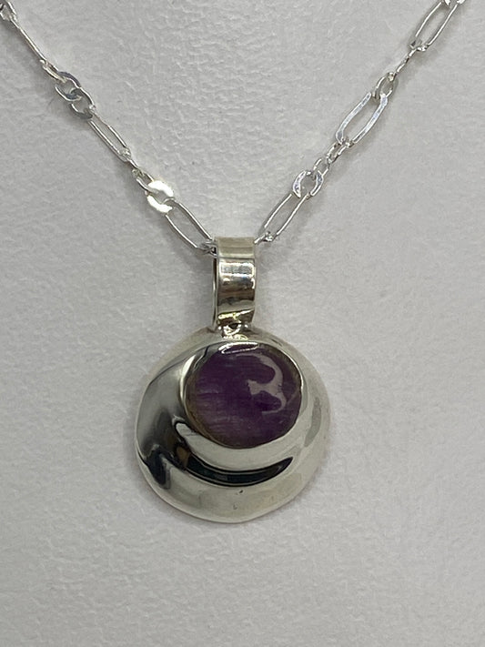 Dije de plata 925 con piedra morada engastada, colgando de cadena en el cuello