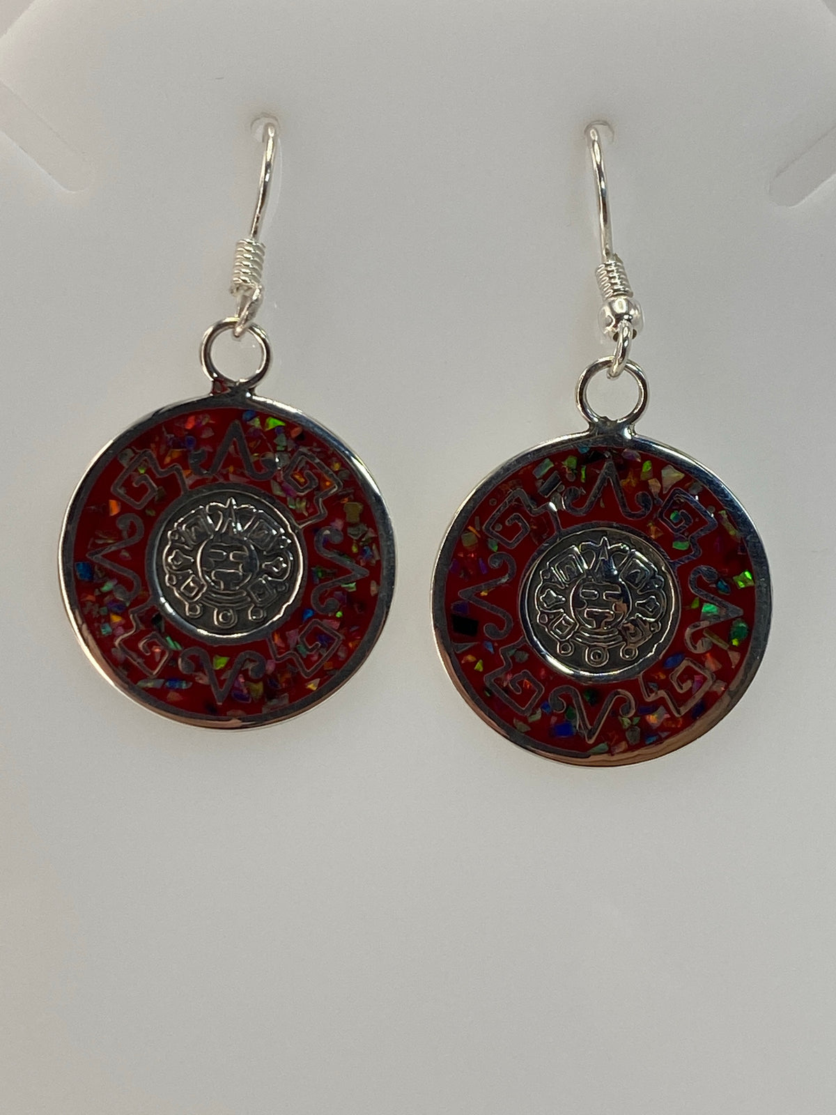Vista frontal de aretes mostrando el juego de colores del ópalo de fuego: rojo, naranja, verde y azul