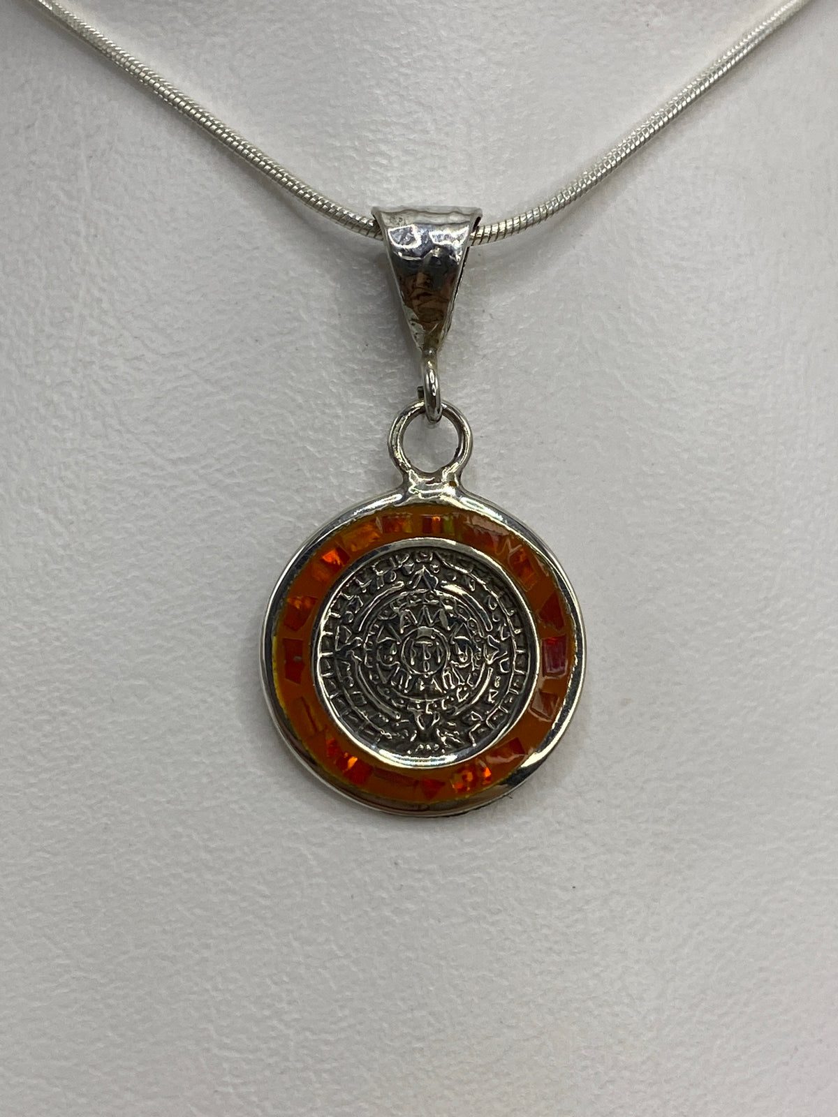 Dije de plata 925 con Calendario Azteca e Ópalo de Fuego naranja, colgando de cadena en el pecho