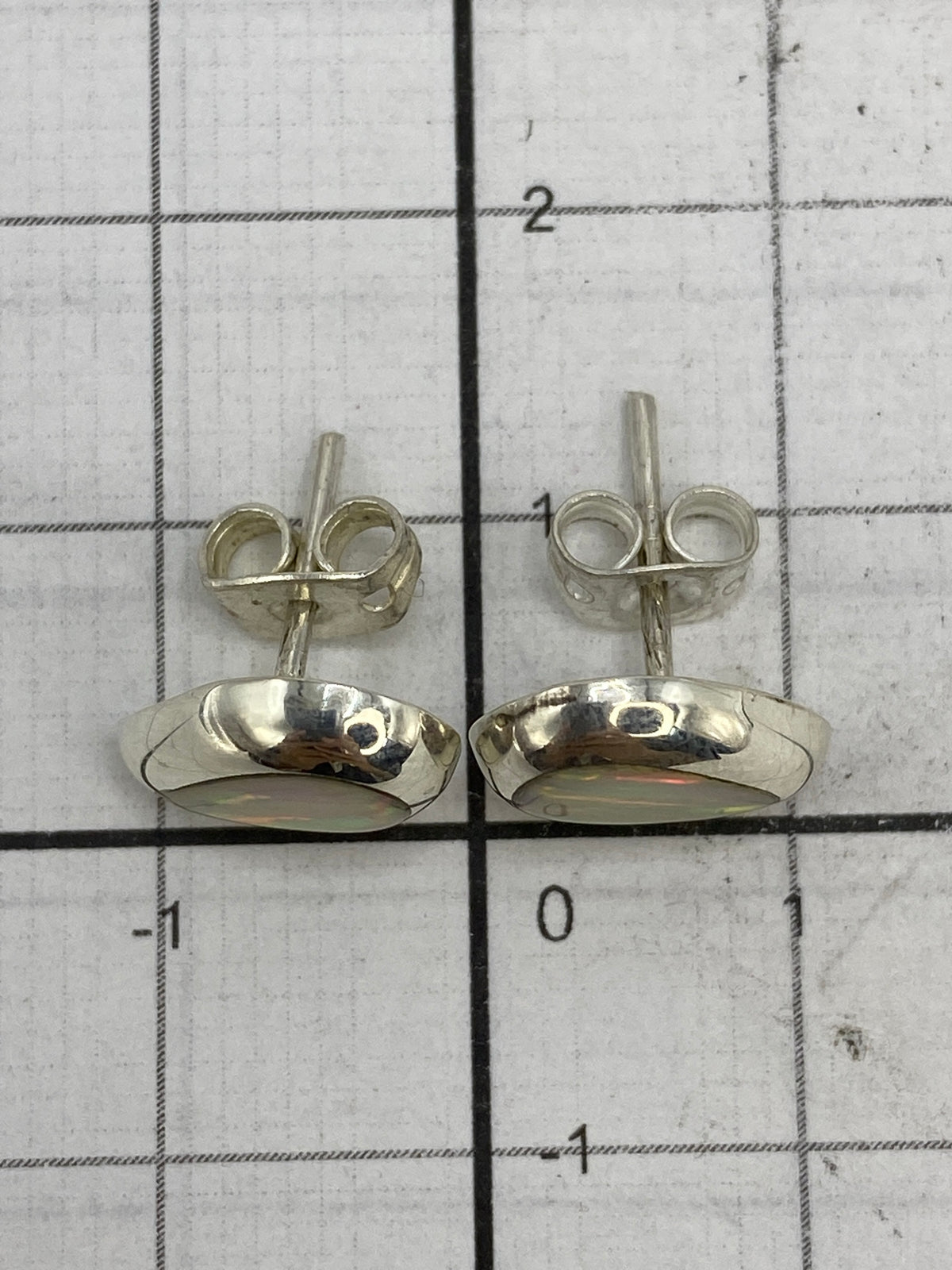 Aretes en la mano para escala de tamaño (1.3 cm de largo)