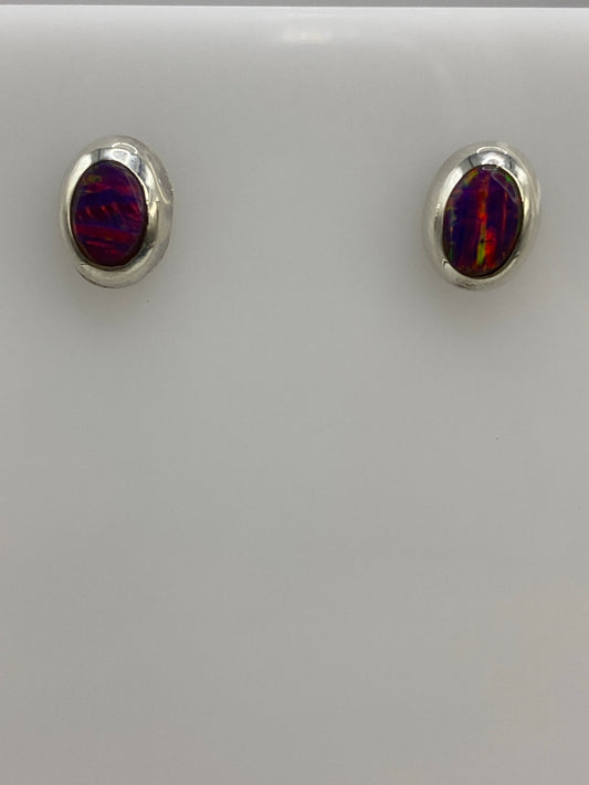 Par de aretes de plata 925 con ópalo de fuego morada, vistos de frente sobre fondo blanco