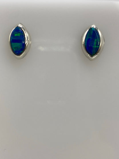 Aretes de plata con ópalo de fuego azul engastado, vistos de frente