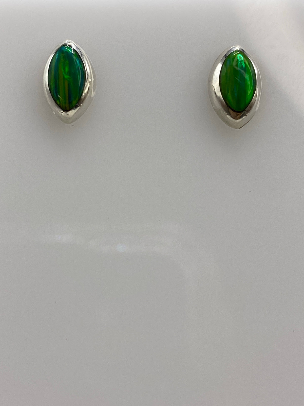 Vista frontal de aretes de plata 925 con ópalo de fuego verde, mostrando el color vibrante de la piedra