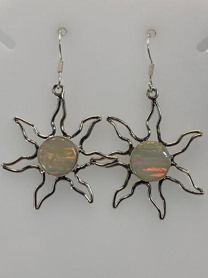 Par de aretes sol de plata 950 con ópalo de fuego naranja y verde, colgando sobre fondo blanco