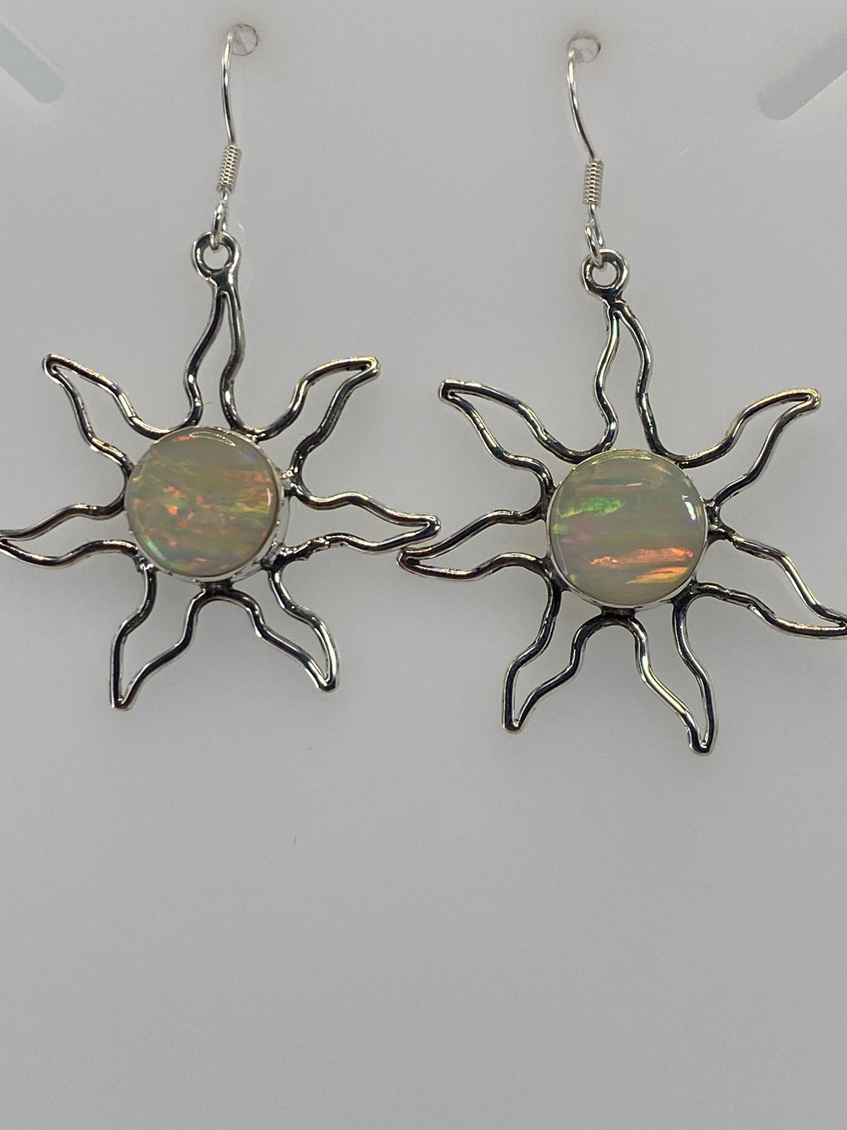 Aretes sol junto a regla de centímetros mostrando tamaño de 4 cm de largo del par