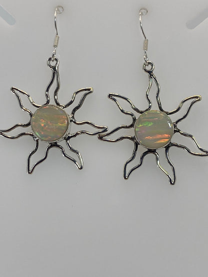 Aretes sol junto a regla de centímetros mostrando tamaño de 4 cm de largo del par