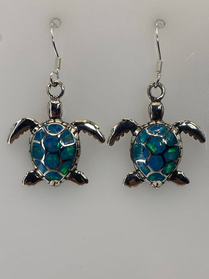 Par de aretes de plata con ópalo de fuego azul cielo, gancho de plata, sobre fondo blanco