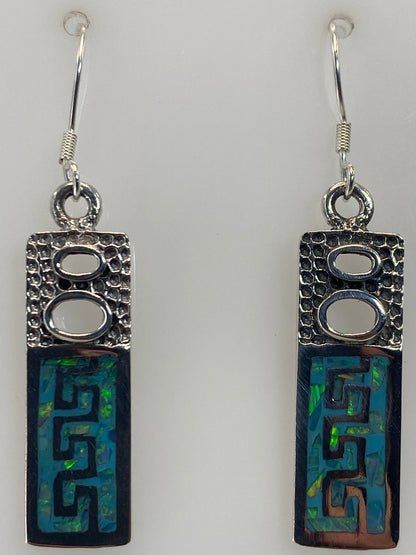 Aretes prehispánicos de Taxco colgando, mostrando la proporción de 4.1 cm y el brillo del ópalo
