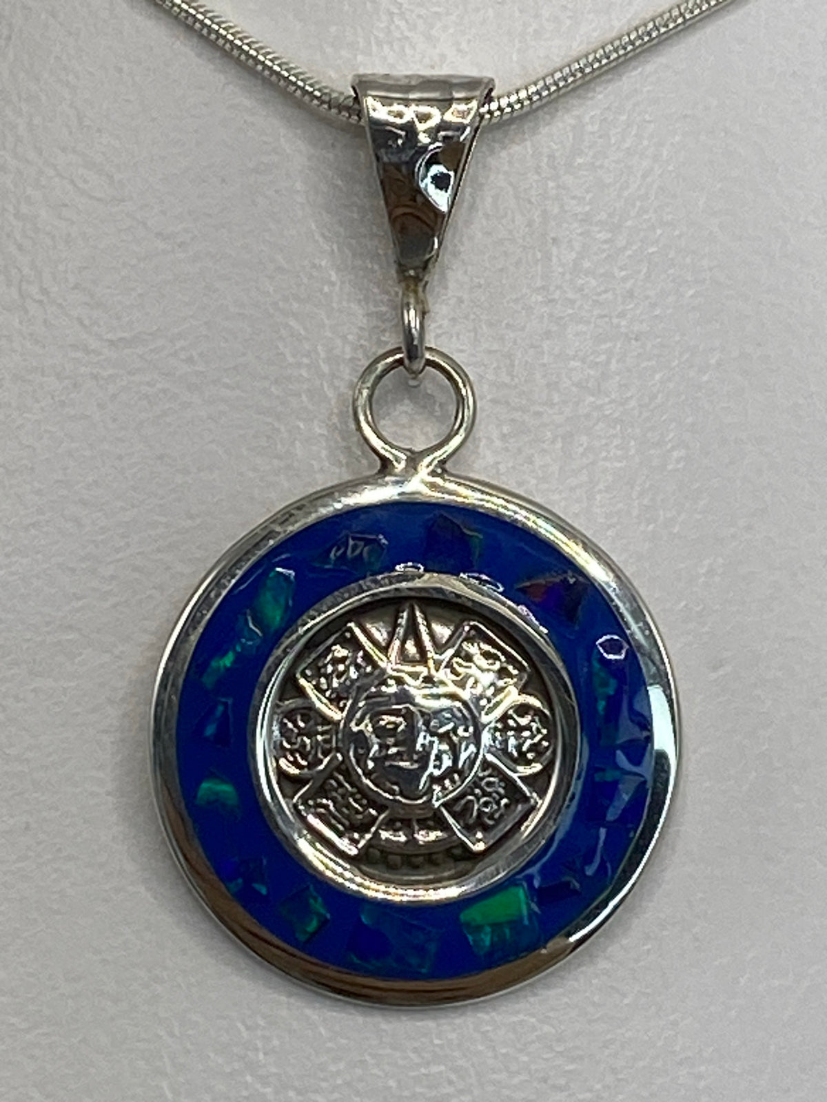 Dije de plata mandala solar con ópalo de fuego multicolor visto de frente en cadena de plata