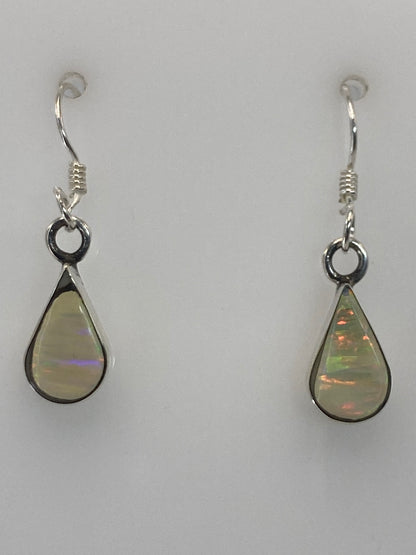 Par de aretes de plata 950 con ópalo de fuego en gancho, mostrando los destellos rojos y naranjas de la piedra