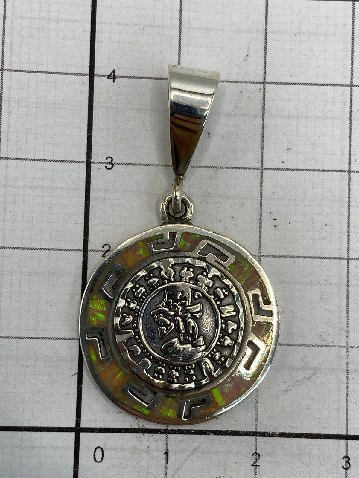 Reverso del dije con marca de autenticidad y el aro de enganche para cadena