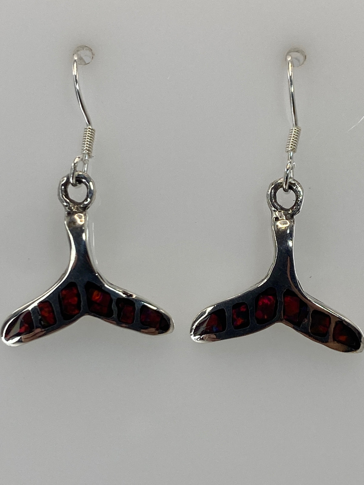 Aretes de frente sobre fondo gris neutro, viendo la proporción de 3 cm