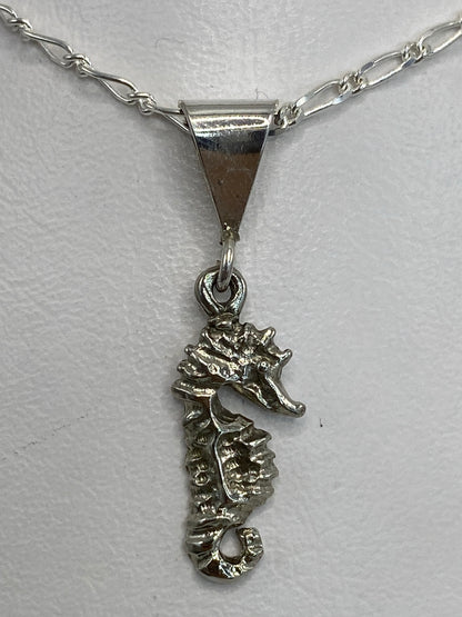 Dije de plata 925 caballito de mar en relieve repujado, sobre fondo blanco