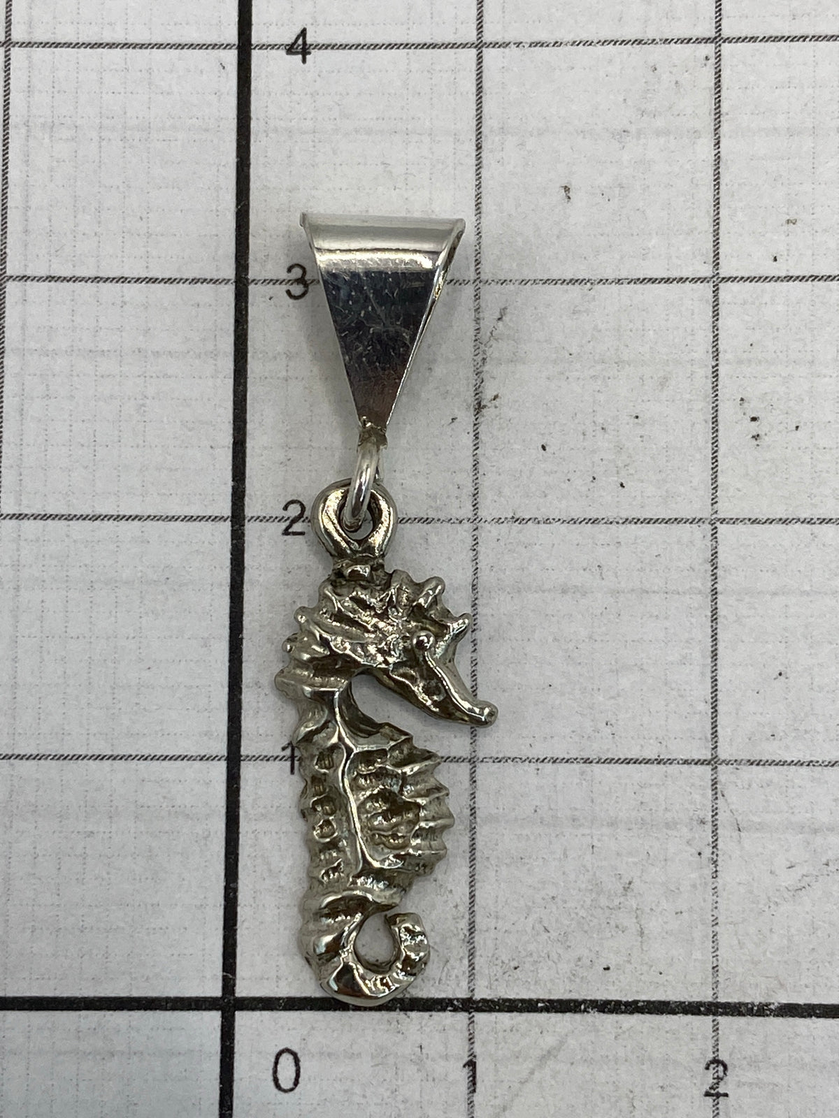 Medida del dije de 3.4 cm sobre regla de centímetros