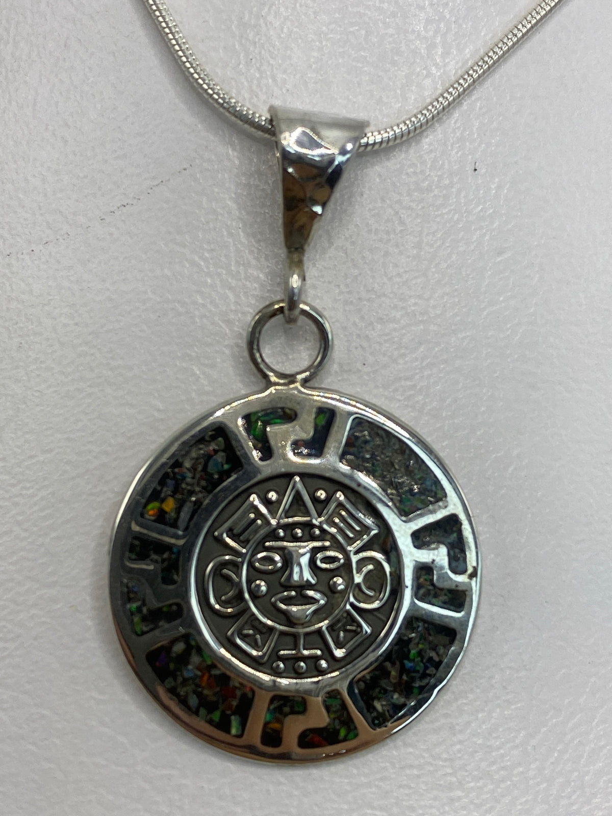 Dije de plata con calendario azteca e ópalo de fuego multicolor colgando de cadena