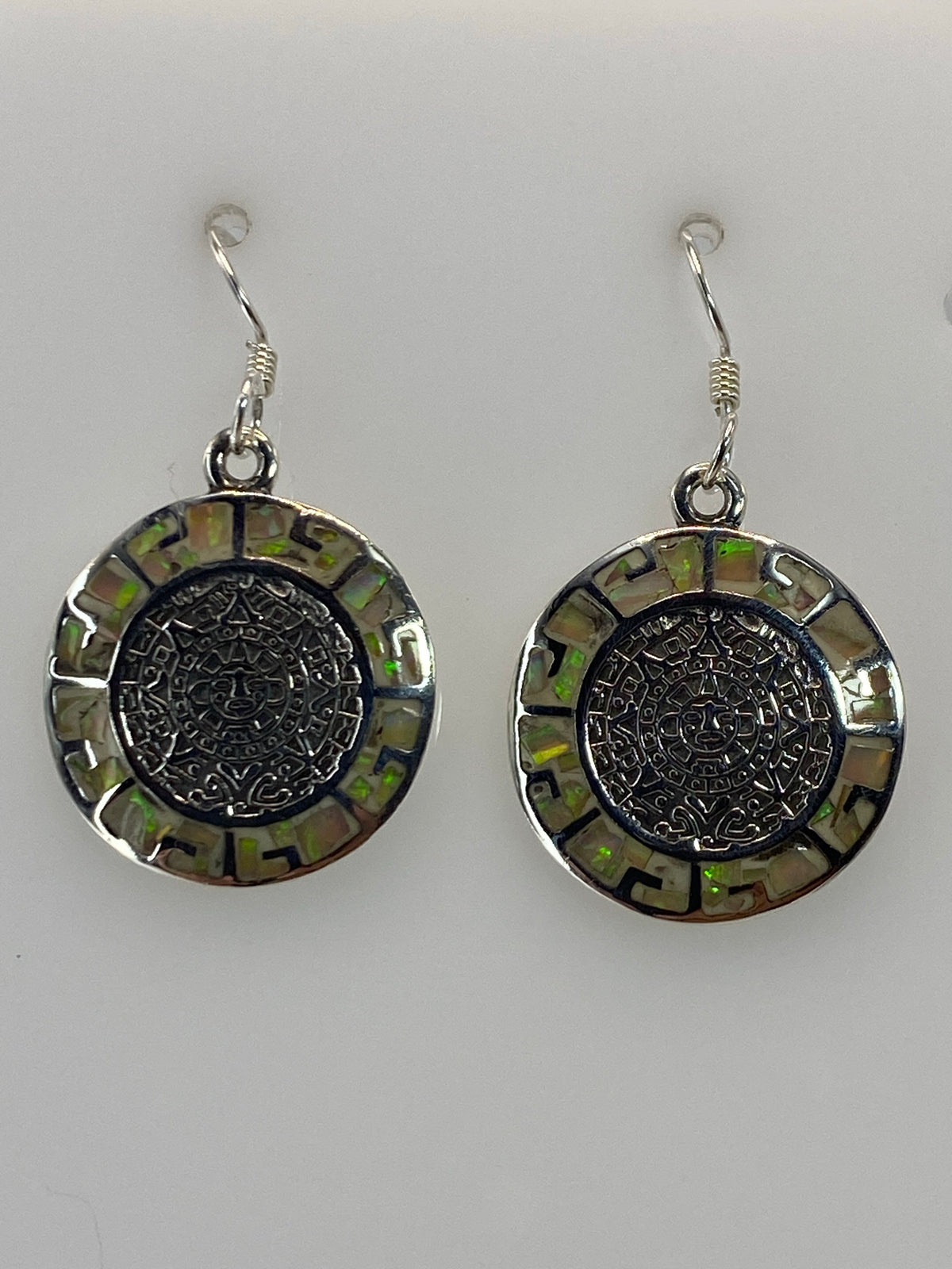 Par de aretes plata 950 con ópalo de fuego multicolor, diseño circular prehispánico, colgando de gancho de plata