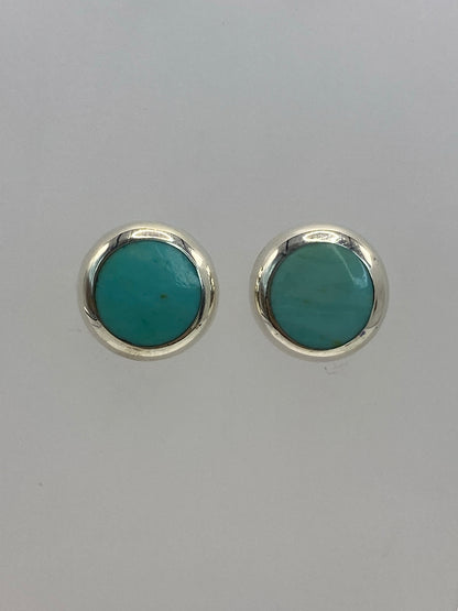 Par de aretes de plata 925 con piedra azul cielo engastada, sobre fondo blanco