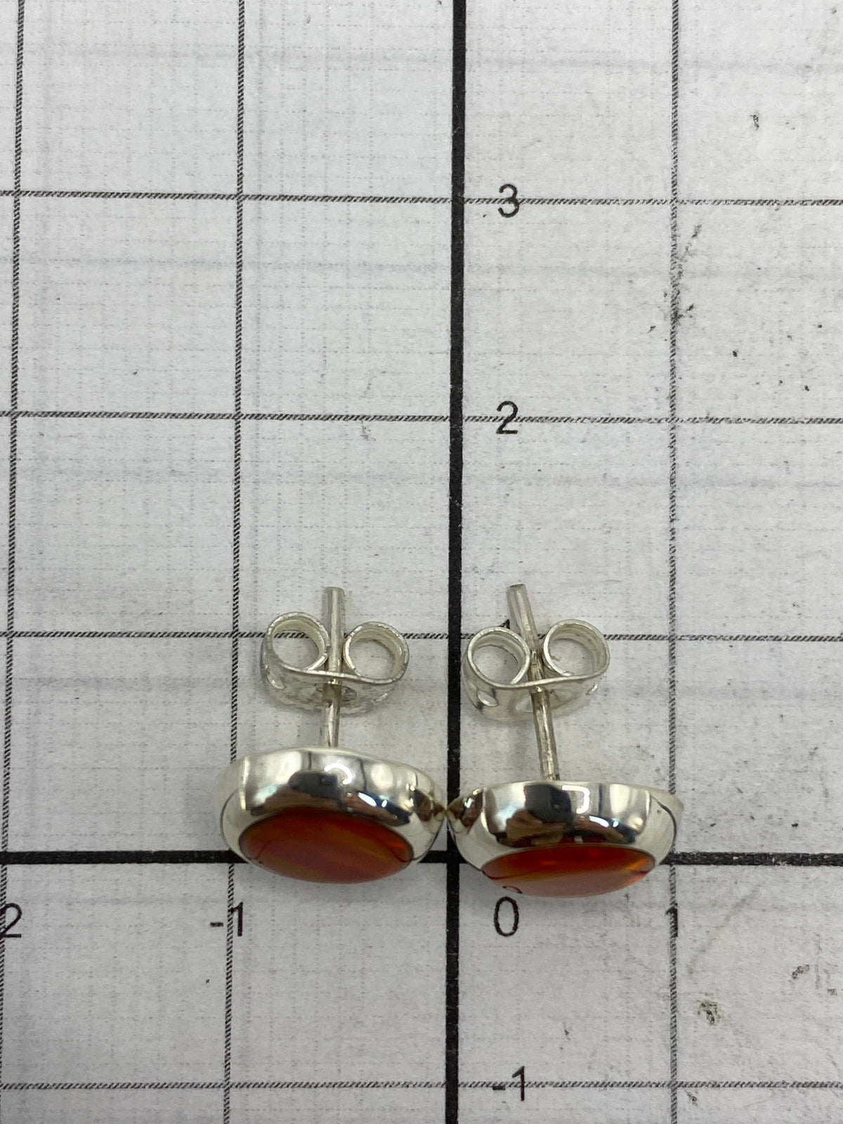 Aretes sobre fondo blanco con escala de medida, mostrando el Quinto 925