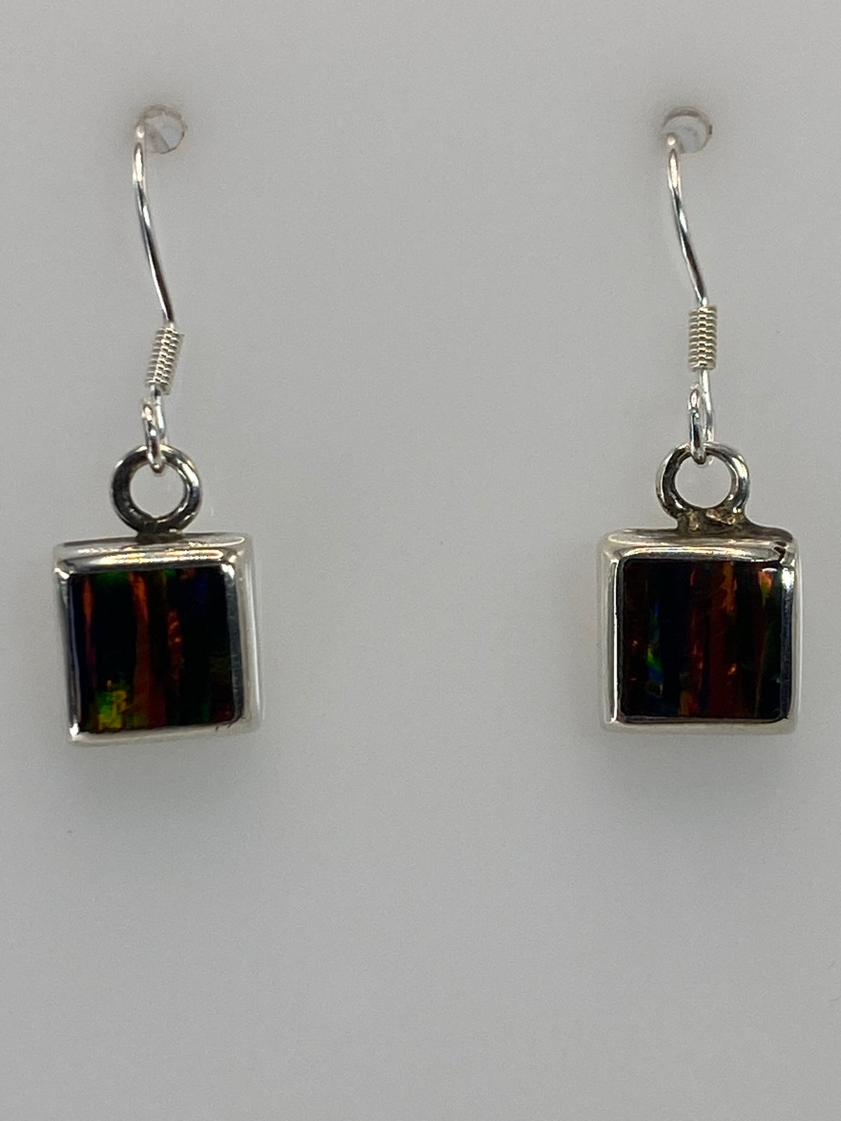 Par de aretes de plata con ópalo de fuego multicolor en la oreja