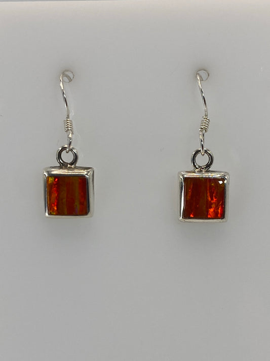 Aretes colgando mostrando el brillo naranja del Ópalo de Fuego