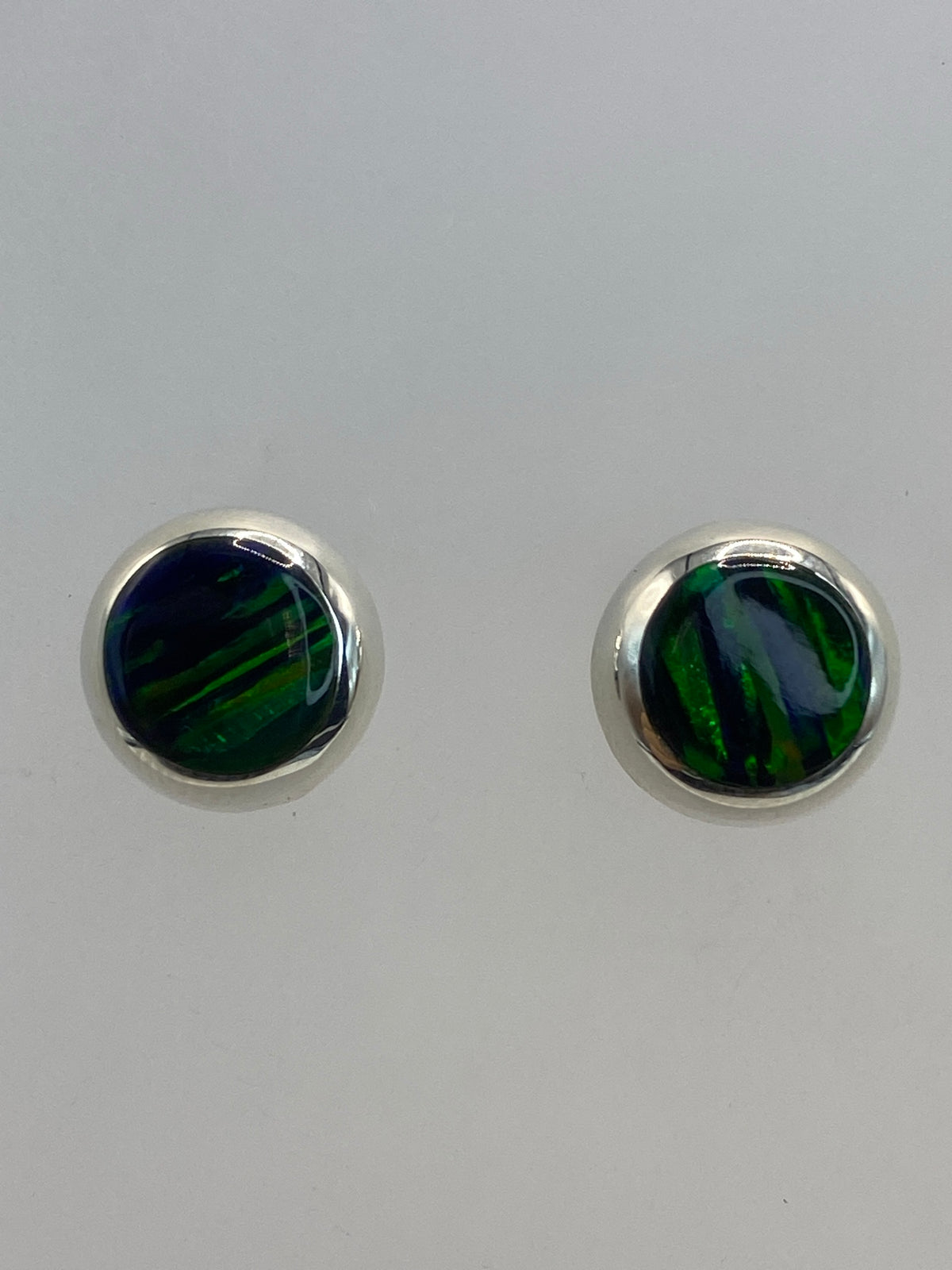 Detalle del engaste a mano de ópalo de fuego en plata, brillo verde intenso
