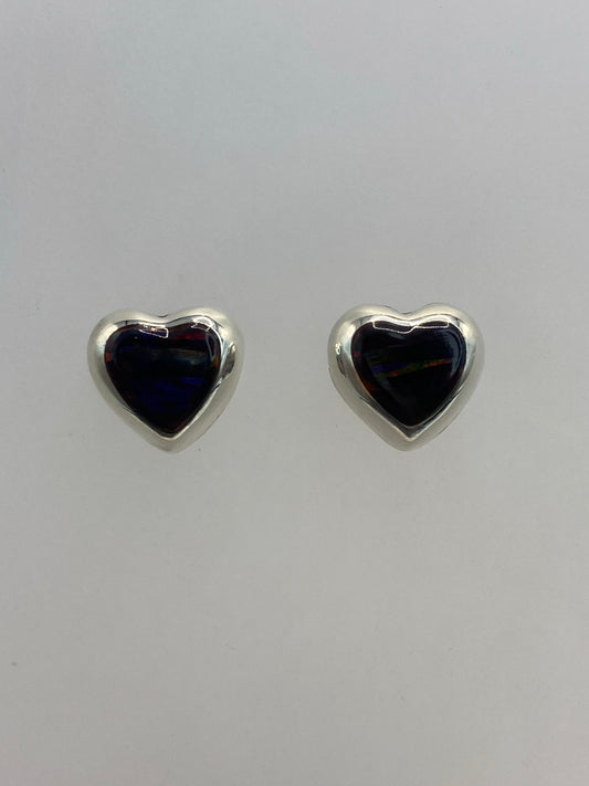 Par de aretes corazón de plata con ópalo de Fuego anaranjado y rojo sobre fondo gris