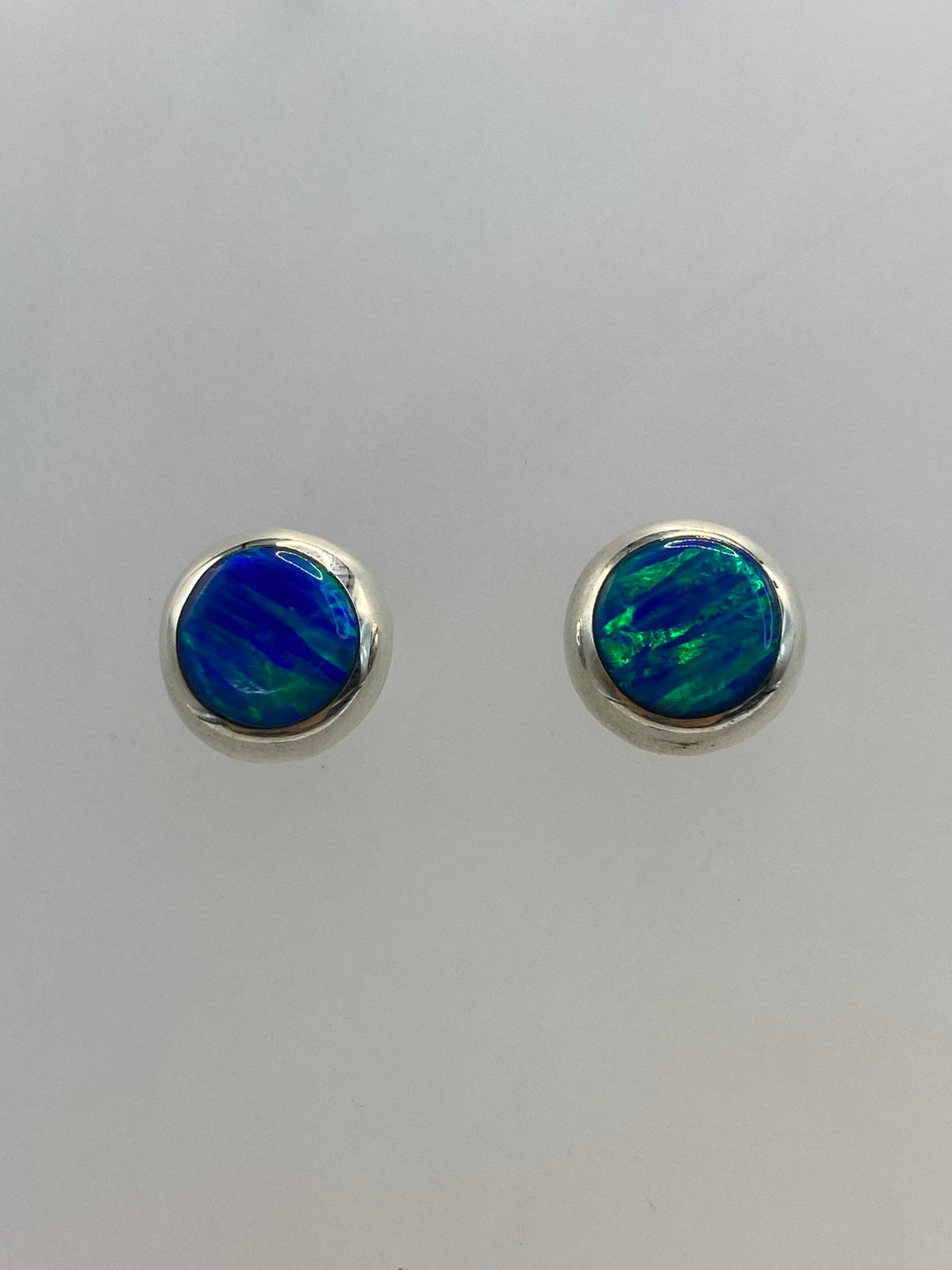 Aretes de plata 925 visto de frente mostrando el color azul de la piedra