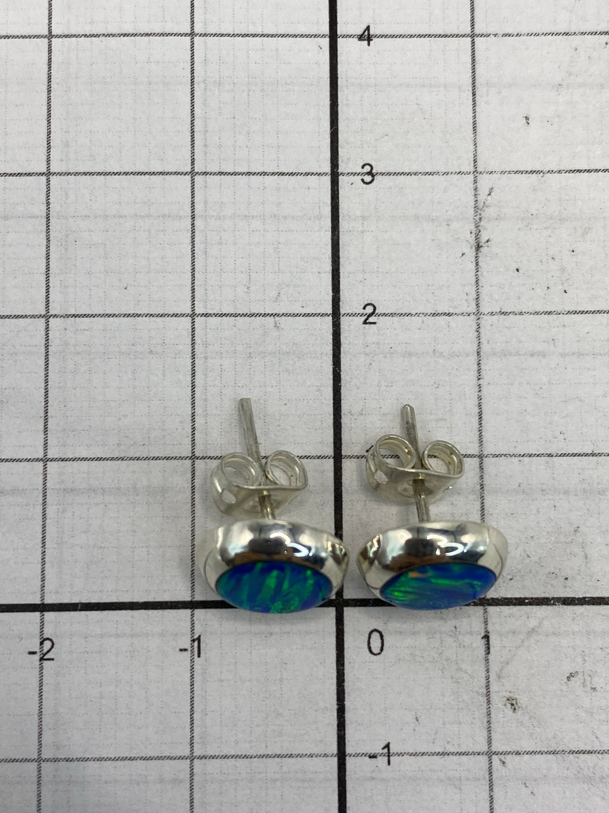 Aretes sobre fondo neutro mostrando el Quinto 925 en la superficie