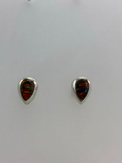 Par de aretes de plata con ópalo de fuego multicolor, vistos de frente en estudio