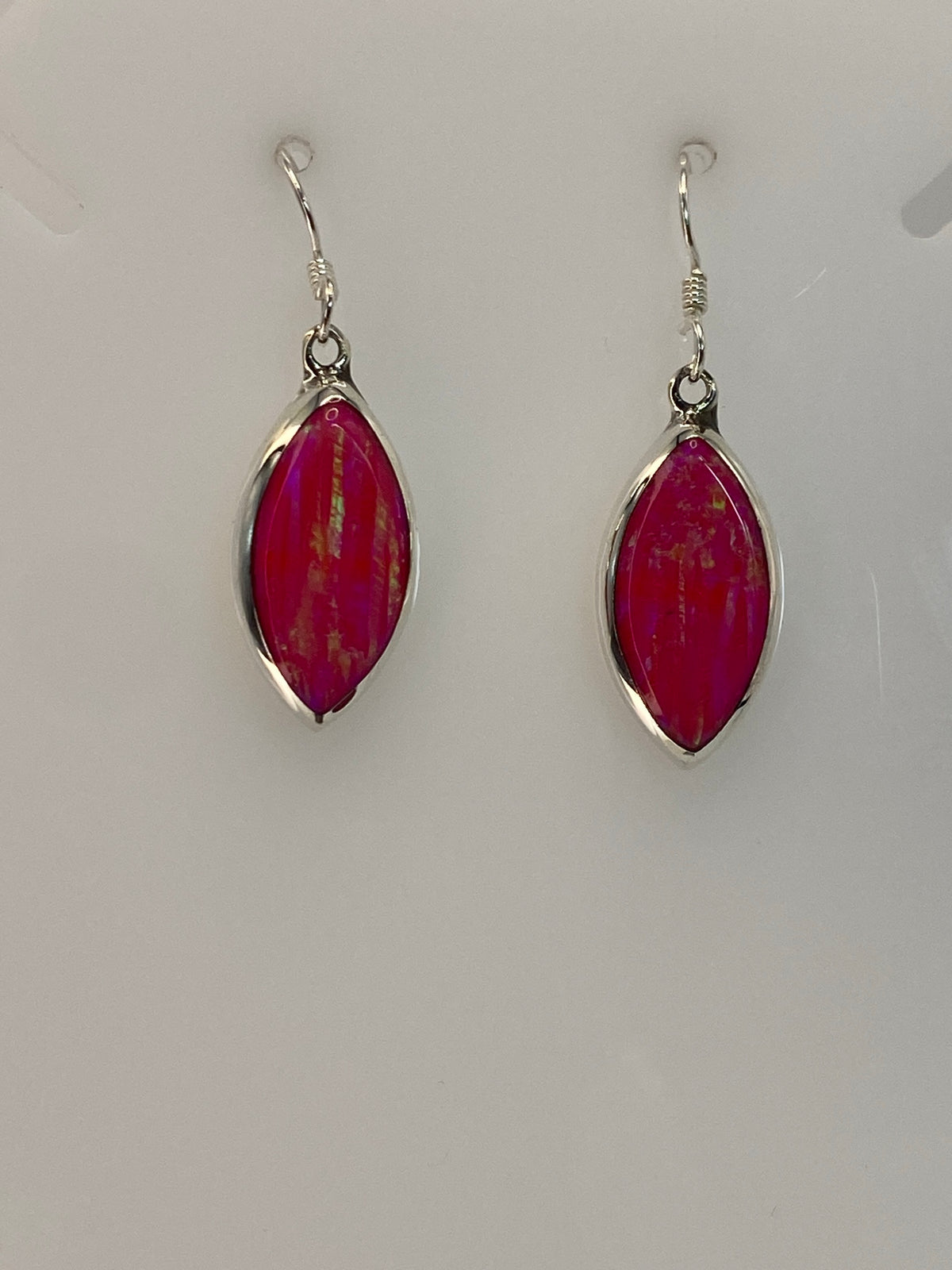 Detalle de la piedra de ópalo de fuego con tonos rosa y naranja, engastada en plata