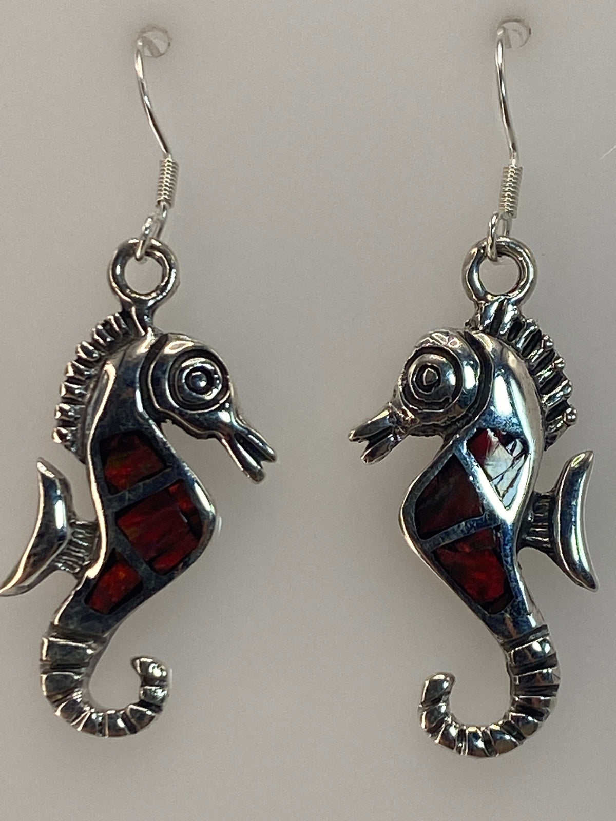 Aretes colgando mostrando el largo de 4.3 cm y el color multicolor del ópalo