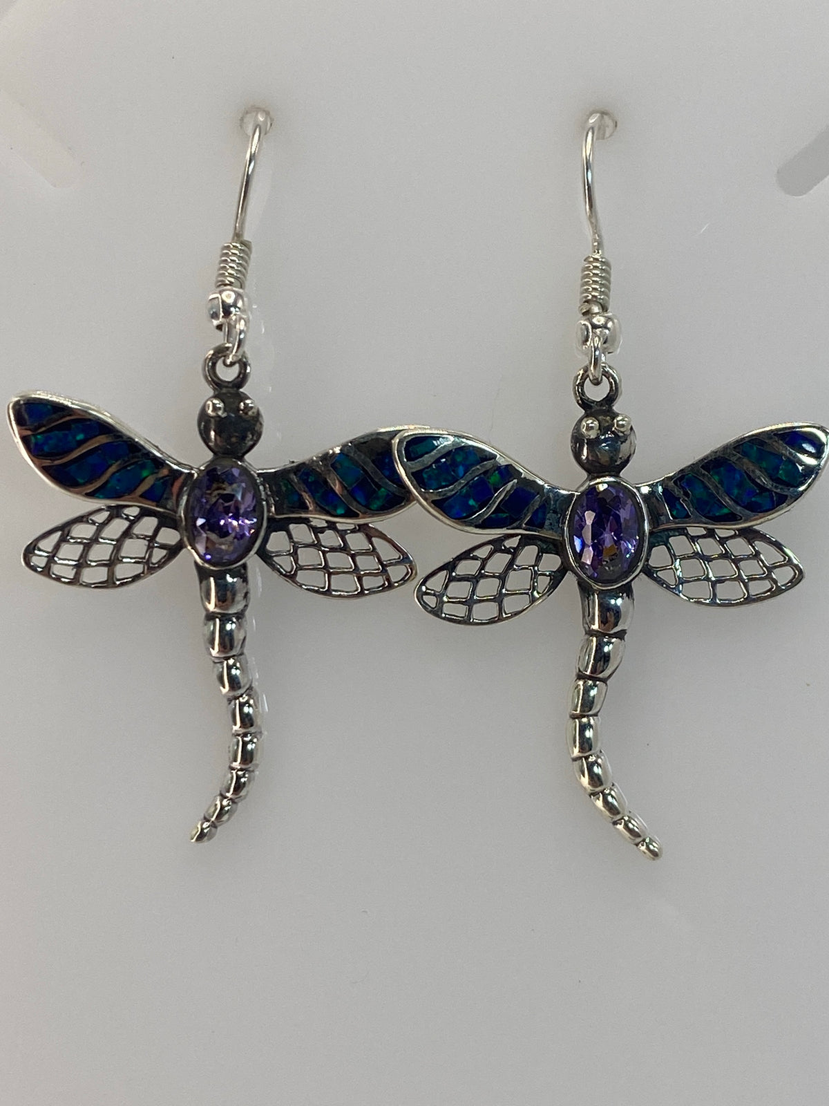 Aretes de plata con ópalo de fuego azul, vistos de frente mostrando el color y brillo de las piedras