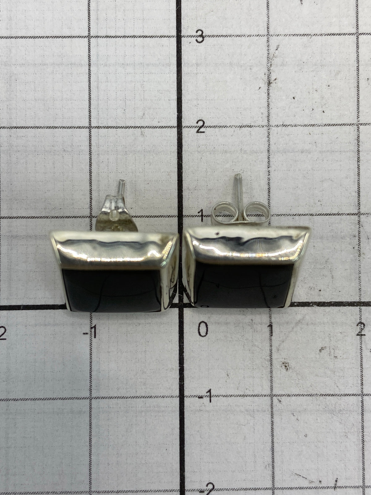 Arete individual de plata con piedra negra y cierre de poste