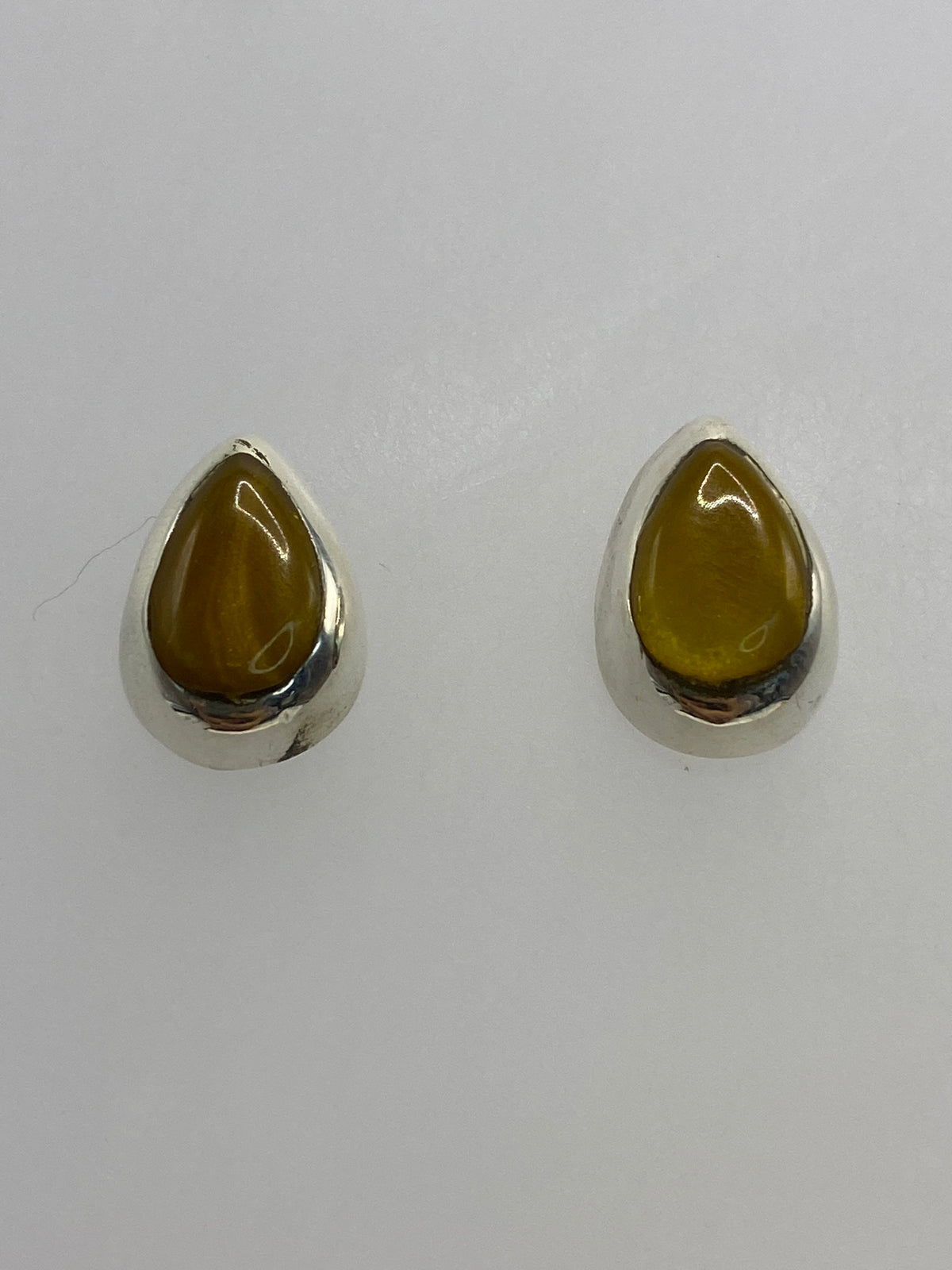 Vista frontal de los aretes con incrustación de piedra multicolor brillo