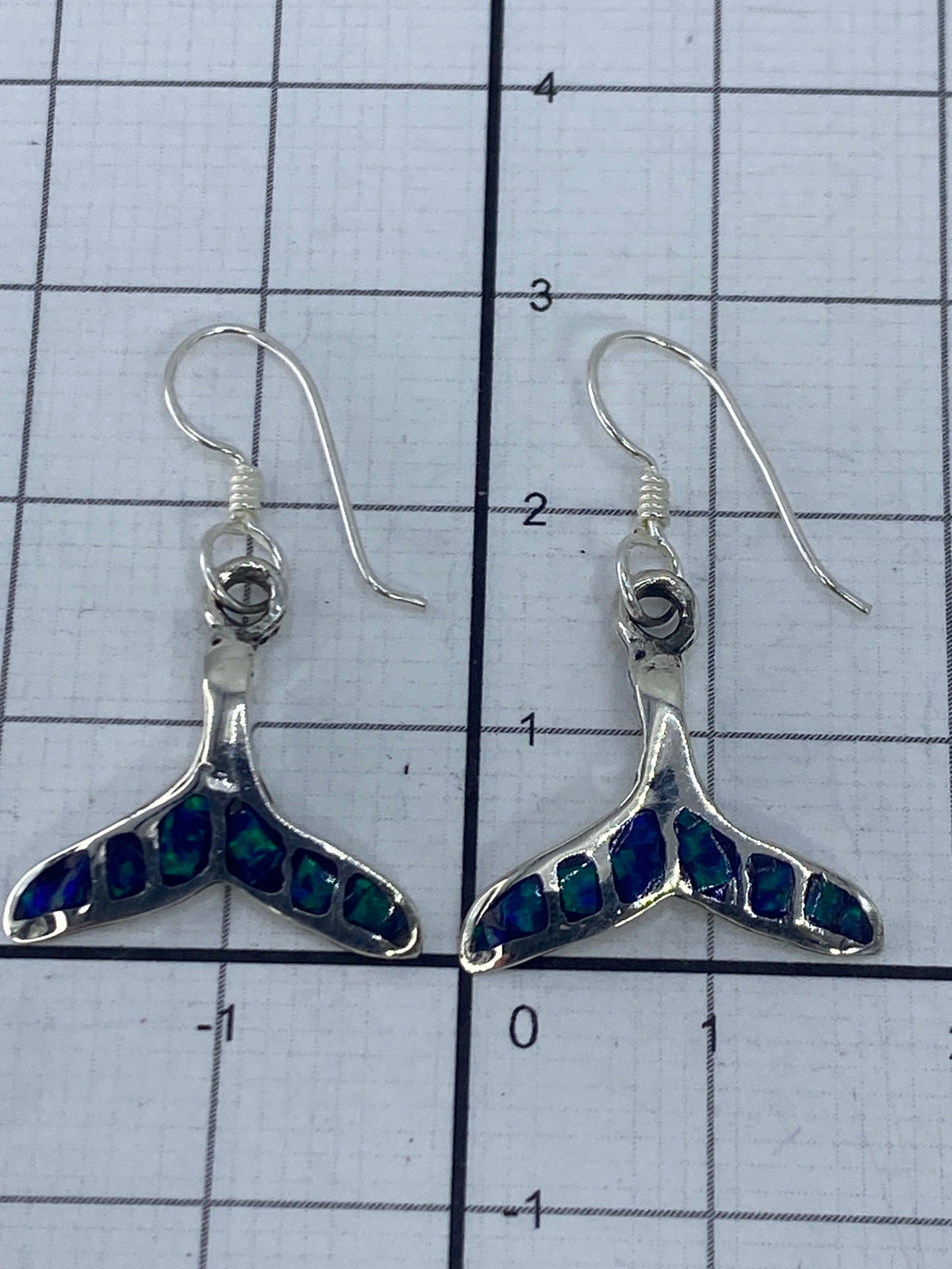 Aretes sobre escala de medición mostrando largo de 2.9 cm