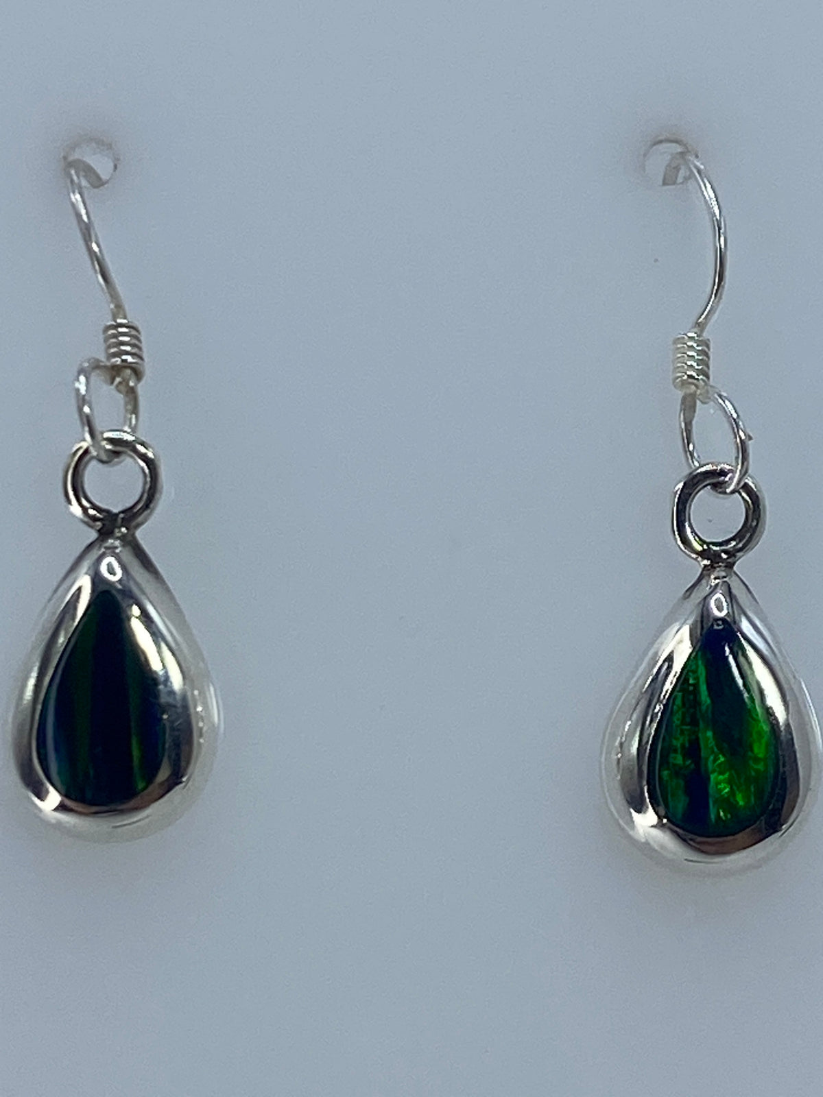 Aretes de 2.7 cm de largo mostrados en la mano para escala