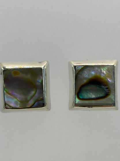 Aretes colocados sobre fondo blanco con la marca 925 visible
